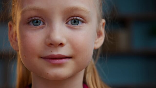 Portrait Caucasian calm beautiful adorable adopted child girl kid smiling looking at camera in evening home cute baby daughter carefree look face smile happy in apartment healthy children headshot