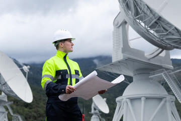 Engineer inspecting satellite communication and observatory systems