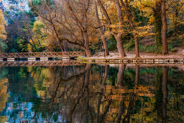Monasterio de Piedra lake reflecting autumn trees and bridge