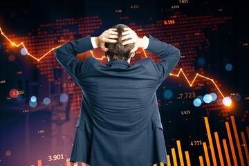 Businessman in despair watching stock market collapse with downward arrows and falling charts on dark abstract background concept of financial crisis.
