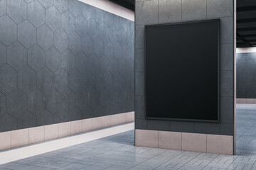 Vertical black blank poster frame on modern stone wall in clean indoor exhibition or gallery room...