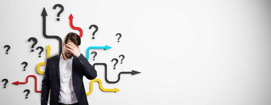 Confused businessman standing in front of colorful arrows and question marks on white background representing direction and decision-making concept. - Powered by Adobe