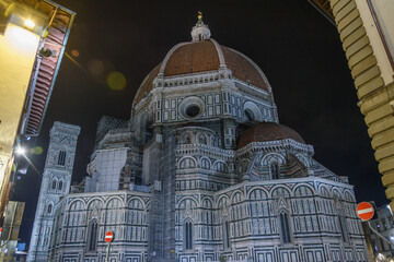 Florence Cathedral with illuminated dome and marble facade at night, Florence, Italy