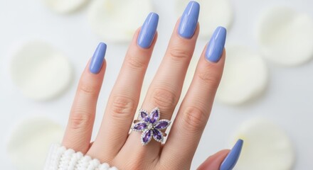 Serene Touch: An elegant hand, adorned with captivating light blue nails and a delicate floral ring, rests gracefully among soft petals, evoking a sense of tranquility and style.
