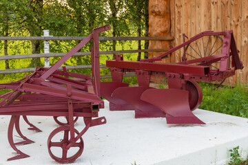 Antique agricultural equipment in a farmyard in the countryside