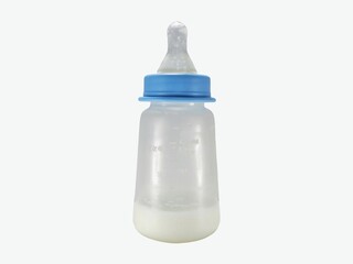 Plastic baby bottle filled with milk, featuring a blue collar and nipple, isolated on a white background.