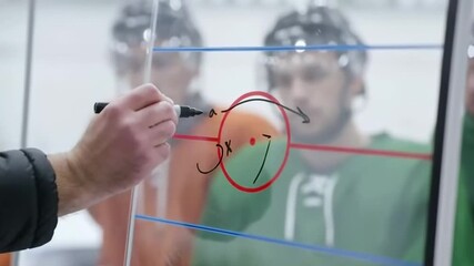 Coach strategizing hockey game plan on glass board with team attentive to strategy