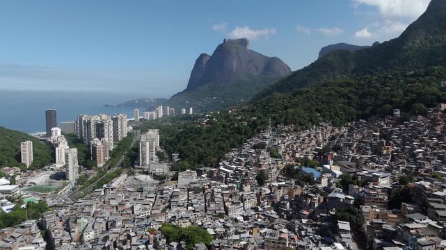 Aerial view of Rio de Janeiro, Brazil, flying over Favela da Rocinha toward Pedra da Gavea on a sunny day.