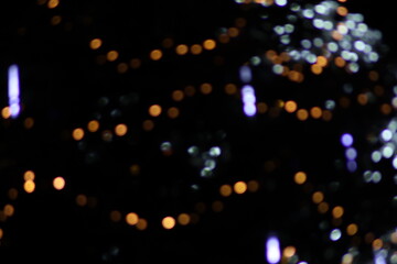 Dense multicolored bokeh Christmas lights background, chaotic texture of purple orange and white defocused circles, festive holiday night party atmosphere wallpaper or backdrop