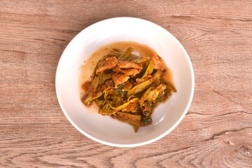 spicy stir fried Thai morning glory with slice fat pork belly in curry sauce on plate 