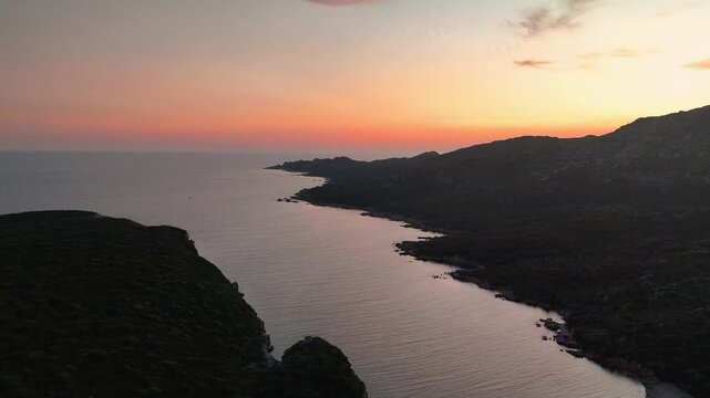Expansive High Altitude Aerial View Soaring Over Plage de Paragan Bay and Capu di Fenu Coastline Illuminated by Golden Hour Sunset, Corsica, France.