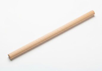 Naklejka premium Fluted wooden dowel rod element rests diagonally across a clean white background