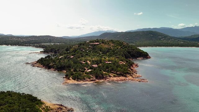 Expansive Aerial Drone Shot Over the Rugged Coastline of Cape Fora and Pinarello Beach, Corsica, France, Featuring Turquoise Mediterranean Water and Pine Forest.