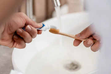 Fotobehang Muziek Hands putting toothpaste on a bamboo toothbrush for daily dental hygiene  © Maria Vitkovska