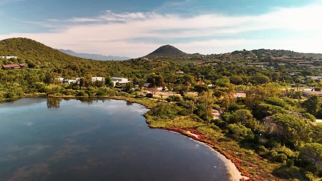 Smooth Aerial Drone Shot Over the Calm, Lush Green Lake and Verdant Forest Landscape Near Santa Giulia Beach, Porto Vecchio, Corsica, France.