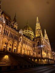 Obraz premium Parliament is illuminated at night in Budapest, Hungary.
