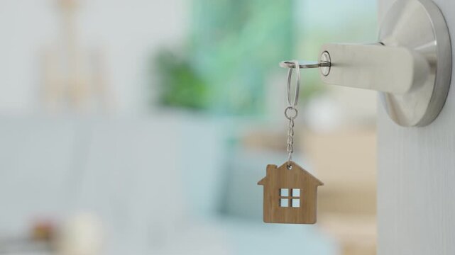 Moving house, relocation. The key was inserted into the door of the new house, inside the room was a cardboard box containing personal belongings and furniture. move in the apartment or condominium