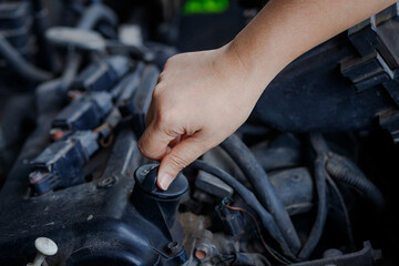 Close up of a  hand of woman is open the engine oil pan cover