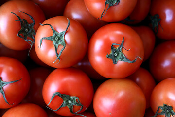 Close-up of a pile of fresh tomatoes. Red in color and delicate in texture. Healthy ingredient, superfood.