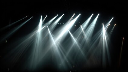 Array of illuminated stage lights piercing the darkness. Beams of light create a dramatic, abstract pattern
