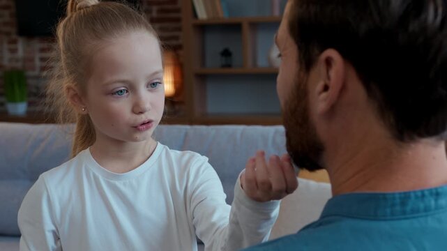 Caucasian family at home talking happy smiling daughter talk with father touching beard tickling game playing kid child girl communicate positive pleasant with daddy spending time together cute moment