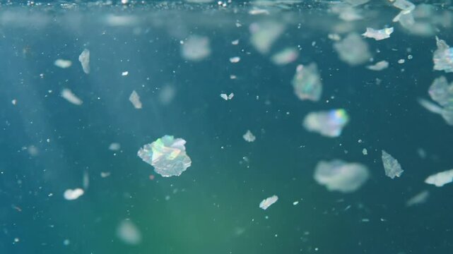 Microscopic particles floating in clean water, revealing their iridescent qualities and subtle textures
