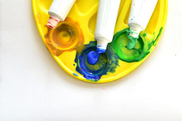 A palette with tubes of acrylic paints in different shades.