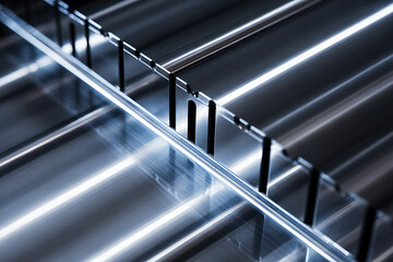 Obraz premium Abstract metallic grid pattern with bright diagonal light reflections creating a futuristic and industrial aesthetic with sharp lines and geometric shapes