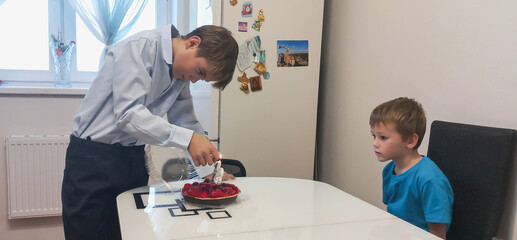 Obraz premium A boy places a at the kitchen table indoors.