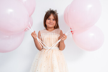 Young caucasian girl in party dress with pink balloons and tiara © Ламина Акулова