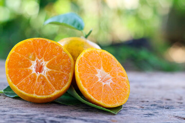 Juicy orange slices on textured wooden floor, warm rustic atmosphere.