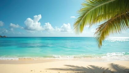 Palm leaves hang over sandy beach and bright blue ocean water. Gentle waves lap shore under clear sky with white clouds. Sunlight sparkles on sea surface, creating tranquil tropical setting.