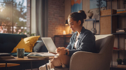 Woman working on laptop sitting in comfortable armchair
