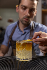 Bartender carefully garnishing a cocktail