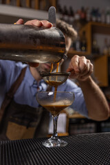 Bartender pouring espresso martini cocktail