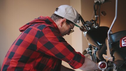 Mechanic repairs motorcycle in workshop during afternoon, showcasing skills and passion for motorbikes and maintenance work