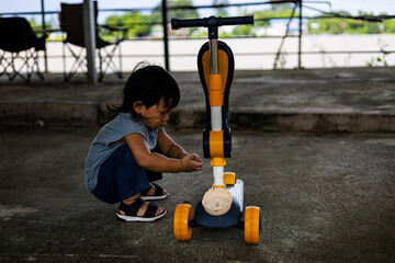 Focused Toddler Fixing Scooter
