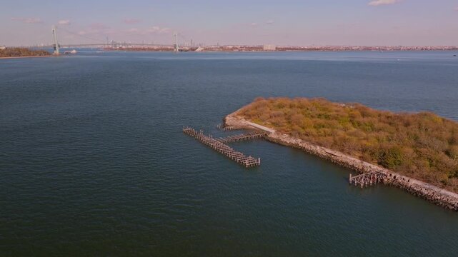 Aerial drone view of Hoffman Island in New York Harbor, a small historic island surrounded by calm open water with the distant coastline visible on the horizon.