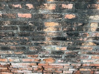 Old brick wall in Thailand, ruins of an old temple, bricks blackened by moisture