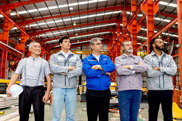 Group of engineers standing line up in manufacturing factory. Corporate engineering workers standing confidently in industrial setting. Diverse professional team look in same direction with visions.