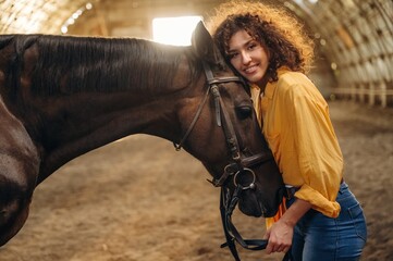 Love and care conception. Beautiful young woman is with horse in hangar