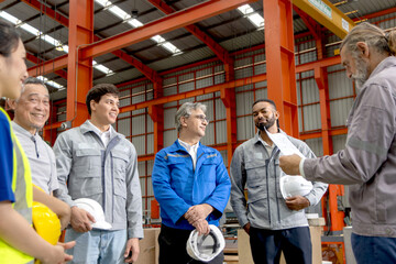 Supervisor of diverse engineers briefing his team before working in manufacturing factory. Leader giving a briefing to team in industrial site. Worker manager conducting a site meeting in a factory.