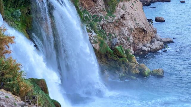 View of the Nizhny Duden waterfalls in Antalya, Turkey. Waterfalls fall from a rocky cliff into the Mediterranean Sea. The cascade is formed by the Duden River, one of the rivers in southern Anatolia.