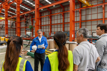 Supervisor of diverse engineers briefing his team before working in manufacturing factory. Leader giving a briefing to team in industrial site. Worker manager conducting a site meeting in a factory.