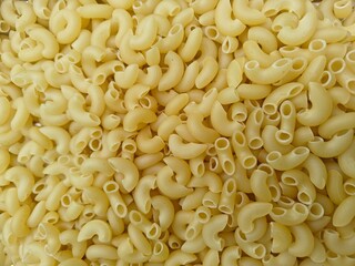 Close up shot of dried uncooked macaroni pasta.