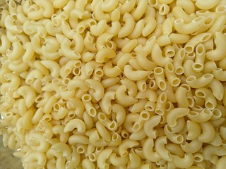 Close up shot of dried uncooked macaroni pasta.