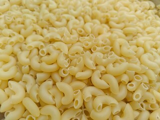 Close up shot of dried uncooked macaroni pasta.