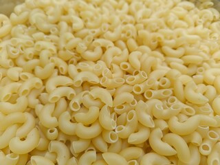 Close up shot of dried uncooked macaroni pasta.
