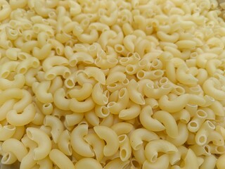 Close up shot of dried uncooked macaroni pasta.