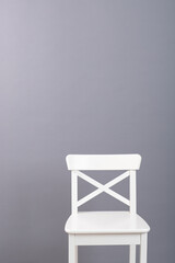 white wooden chair on a gray wall background